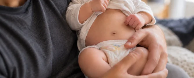 Father holding a baby with the baby's tummy visible